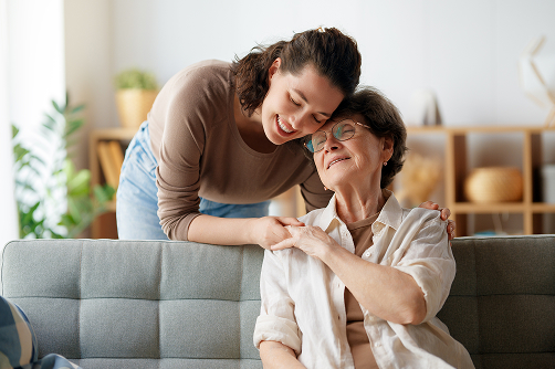 Caregiver comforting senior woman at home