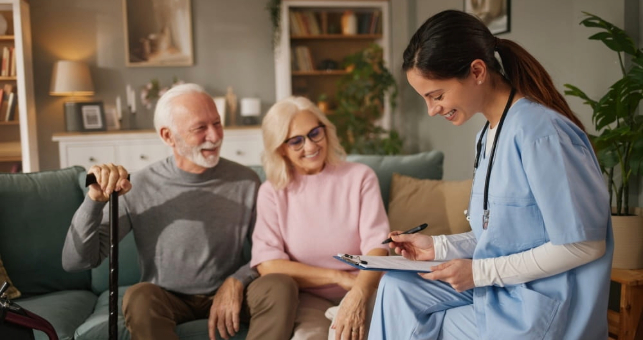 Care worker supporting senior woman in room