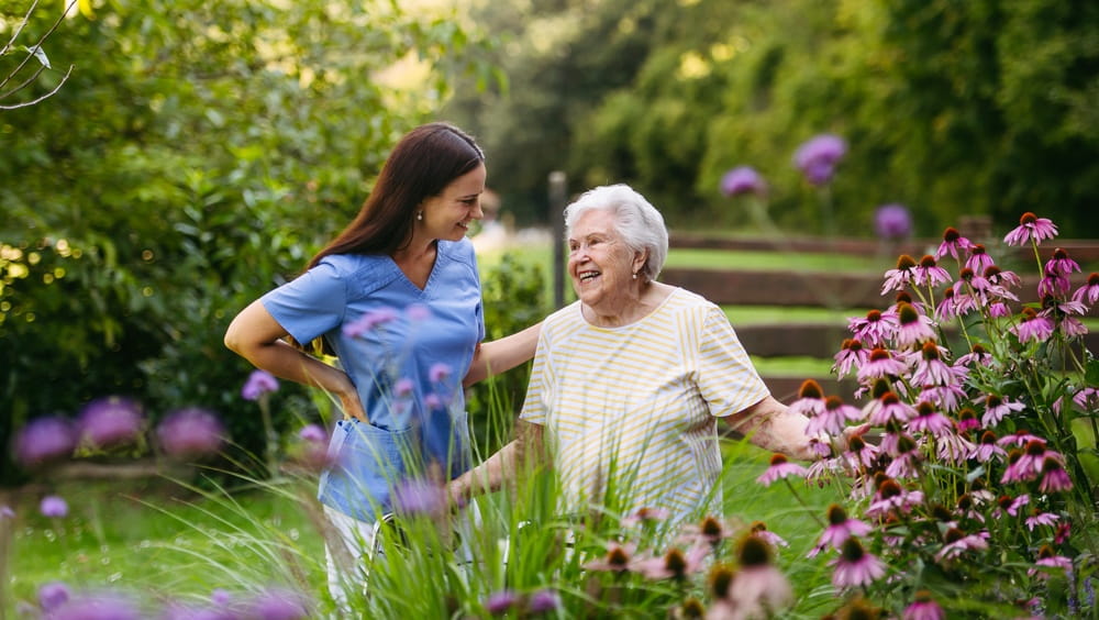 Home nurse spending time with elderly lady in garden