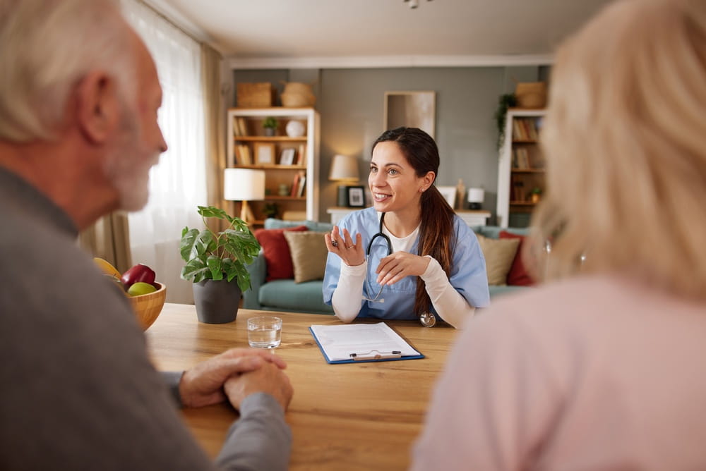 Nurse guiding elderly couple at home