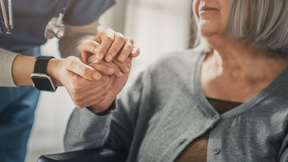 Nurse holding hand of elderly patient
